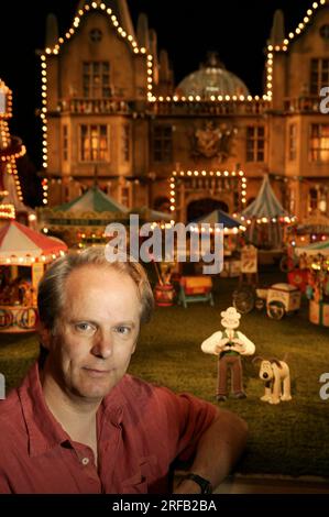 Portrait de Nick Park, créateur de personnages animés 'Wallace et Grommit' photographié avec une toile de fond qui est une scène de son film, 'Wallace et Grommit, la malédiction du lapin' dans ses studios Aardman, Bristol, Royaume-Uni. Banque D'Images