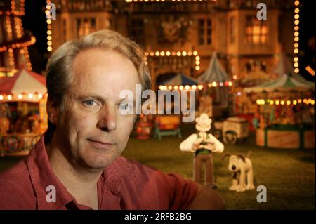 Portrait de Nick Park, créateur de personnages animés 'Wallace et Grommit' photographié avec une toile de fond qui est une scène de son film, 'Wallace et Grommit, la malédiction du lapin' dans ses studios Aardman, Bristol, Royaume-Uni. Banque D'Images