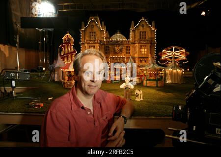 Portrait de Nick Park, créateur de personnages animés 'Wallace et Grommit' photographié avec une toile de fond qui est une scène de son film, 'Wallace et Grommit, la malédiction du lapin' dans ses studios Aardman, Bristol, Royaume-Uni. Banque D'Images