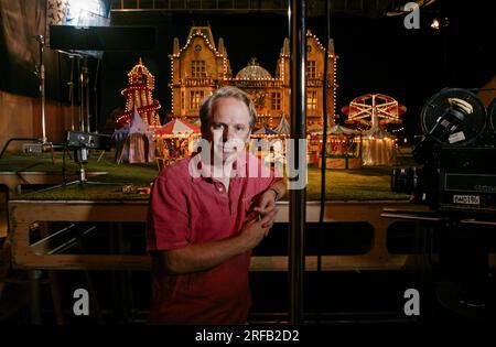 Portrait de Nick Park, créateur de personnages animés 'Wallace et Grommit' photographié avec une toile de fond qui est une scène de son film, 'Wallace et Grommit, la malédiction du lapin' dans ses studios Aardman, Bristol, Royaume-Uni. Banque D'Images