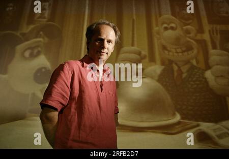 Portrait de Nick Park, créateur de personnages animés 'Wallace et Grommit' photographié avec une toile de fond qui est une scène de son film, 'Wallace et Grommit, la malédiction du lapin' dans ses studios Aardman, Bristol, Royaume-Uni. Banque D'Images