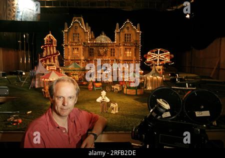 Portrait de Nick Park, créateur de personnages animés 'Wallace et Grommit' photographié avec une toile de fond qui est une scène de son film, 'Wallace et Grommit, la malédiction du lapin' dans ses studios Aardman, Bristol, Royaume-Uni. Banque D'Images