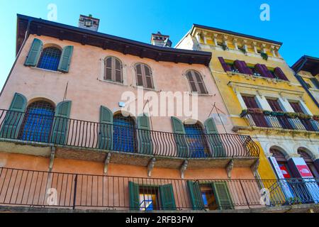 Pittoresques maisons colorées et marché à Piazza delle Erbe dans la vieille ville de Vérone, Italie. La ville de Vérone est un site du patrimoine mondial de l'UNESCO. Banque D'Images