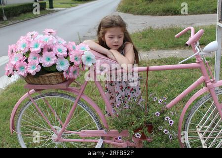 Littlr fille whit le vieux vélo vintage Banque D'Images