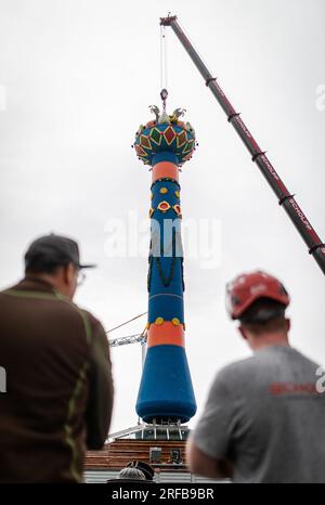 Stuttgart, Allemagne. 02 août 2023. Deux hommes regardent la colonne de fruits érigée au Cannstatter Wasen. La colonne de fruits est le point de repère de la 176e Cannstatter Volksfest, qui aura lieu du 22 septembre au 8 octobre 2023. Crédit : Christoph Schmidt/dpa/Alamy Live News Banque D'Images