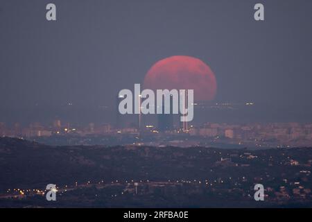 Madrid, Espagne. 01 août 2023. La pleine superlune du mois d'août, connue sous le nom de Sturgeon Moon, s'élève au-dessus de la ligne d'horizon avec les gratte-ciel du quartier d'affaires des quatre tours de Madrid. Crédit : Marcos del Mazo/Alamy Live News Banque D'Images