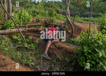 23 juin 2023, Churachandpur, Manipur, Inde : Ngaizuol, -Âgé de 23 ans, un jeune Kuki armé, se cache dans la jungle lors d’un programme d’entraînement dans un village de Churachandpur, dans l’État indien du Manipur, au nord-est du pays. Les jeunes des tribus Kuki''« Zo du Manipur ont pris les armes pour protéger leur village des menaces extérieures, en particulier de leurs ennemis, les Meiteis, qui vivent dans la vallée. Avec un fort sentiment d’unité et de détermination à protéger leurs terres, les jeunes du village ont formé une force de défense et se sont armés de fusils à canon unique approuvés par le gouvernement du Manipur. Collisions Banque D'Images