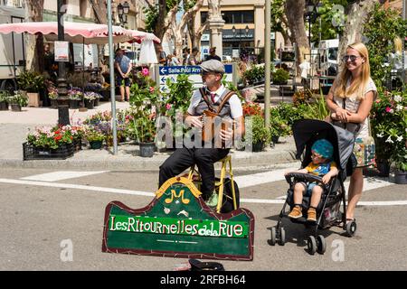 Stree musicienne et jeune femme avec enfant en poussette, Marseillan, Hérault, Occitanie, France Banque D'Images