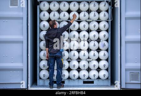 Rostock, Allemagne. 02 août 2023. Un employé vérifie les récipients sous pression contenant du biométhane au nouveau dépôt de Rostocker Straßenbahn AG (RSAG). Le biométhane est un gaz certifié issu de déchets agricoles. Avec ce carburant, les bus biométhane ont une empreinte CO2 similaire à celle des bus électriques chargés en électricité verte. Après six mois de travaux de transformation, le site est adapté aux autobus de service régulier pour des systèmes de propulsion alternatifs. Crédit : Jens Büttner/dpa/Alamy Live News Banque D'Images