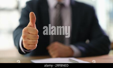 La main de l'homme en costume montre les pouces vers le haut dans le bureau Banque D'Images