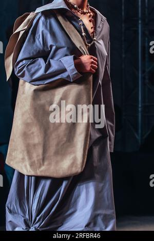 Figure recadrée de femme modèle de mode portant une longue robe bohème bleue et sac à main marron. Photo stylée et tendance. Concept de vêtements de style urbain décontracté Banque D'Images