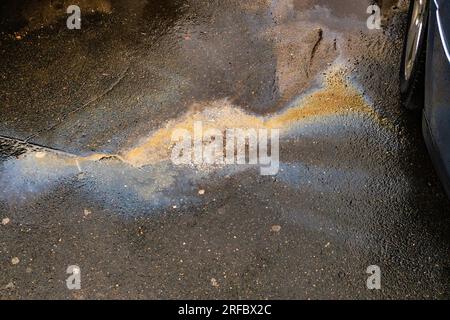 Fuite d'huile ou d'essence de la voiture sur l'asphalte dans le stationnement. Banque D'Images