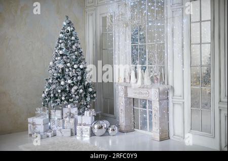 Intérieur de noël confortable du salon avec sapin de noël givré et cadeaux blancs Banque D'Images