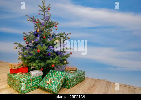 Cadeaux emballés dans un joli papier de couleur et chat sous l'arbre de Noël. Pologne, Europe Banque D'Images