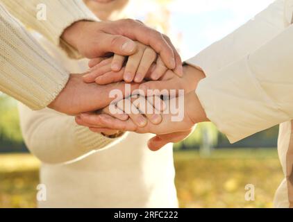 Gros plan de trois personnes caucasiennes empilent leurs paumes. Père, mère et fils tenant leurs mains ensemble. Geste signe de soutien et d'amour, unité tog Banque D'Images