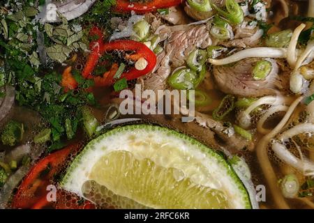 Soupe FO-bo faite de bœuf aux épices et aux nouilles de riz, sur fond noir Banque D'Images