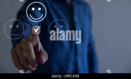 Service à la clientèle et concept de satisfaction, homme d'affaires pressant émoticône visage smiley sur l'écran tactile virtuel. Sur le visage Happy Smiley. Banque D'Images