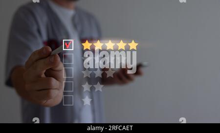 Gros plan d'un client MAN donnant une note de cinq étoiles sur son smartphone. Utilisation de la technologie pour l'évaluation, la cote de service. Banque D'Images