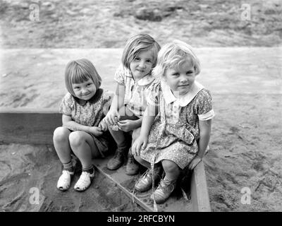 Trois enfants jouant dans un bac à sable, camp de migrants de Tulare, Visalia, Californie, Arthur Rothstein, ÉTATS-UNIS Farm Security Administration, mars 1940 Banque D'Images