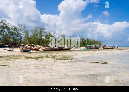 Bateaux de pêche en bois amarrés sur la plage en raison de marée basse au village de Kendwa, journée ensoleillée, Zanzibar, Tanzanie Banque D'Images