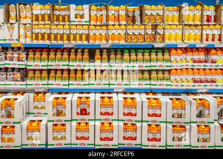 Italie - 02 août 2023 : jus de fruits en bouteilles en plastique et en cartons présentés sur des étagères à vendre dans un supermarché italien à prix réduit Banque D'Images