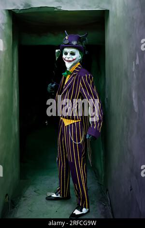 HARROGATE, ROYAUME-UNI - 3 JUIN 2023. Un cosplayer masculin habillé comme le joker des films de batman avec masque et fond grunge Banque D'Images