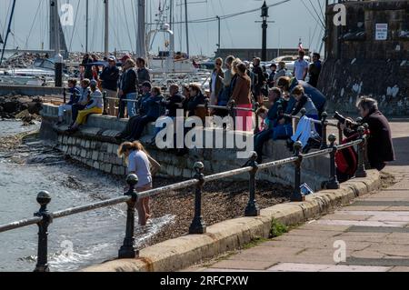 des foules assises sur le mur de l'escadron royal de yachts à cowes regardent pendant la régate annuelle de la semaine cowes sur l'île de wight. Banque D'Images