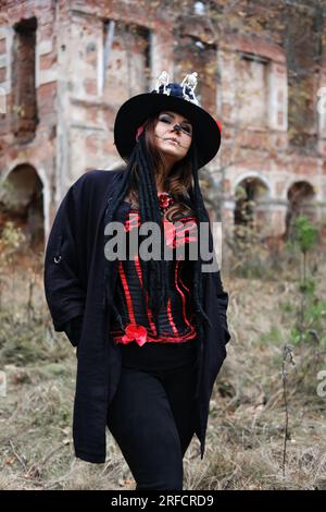 Portrait d'une femme avec un maquillage de crâne habillé en corset, cardigan et un haut-chapeau. Baron samedi. Baron Samedi. Dia de los muertos. Jour des morts. Banque D'Images