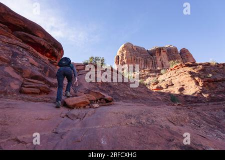 Une femme grimpe sur les rochers vers Cathedral Rock à Sedona Arizona aux Etats-Unis Banque D'Images