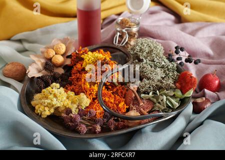 Assiette avec matière végétale pour la teinture organique de tissus sur fond de tissus teints à la main Banque D'Images