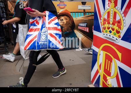 Les visiteurs de la capitale et les Londoniens passent par des panneaux de souvenirs touristiques qui présentent Paddington Bear à Piccadilly Circus dans le West End, le 25 juillet 2023, à Londres, Angleterre. Banque D'Images