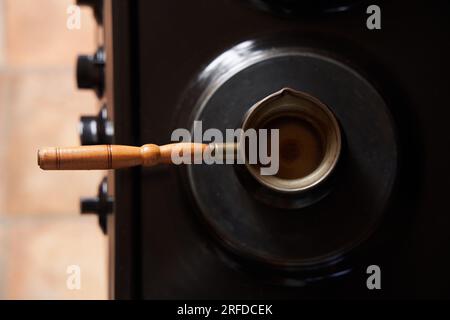 Un homme préparant du café noir sur une cuisinière électrique. Préparez du café dans une cafetière turque. Banque D'Images