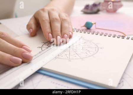 Astrologue utilisant la roue du zodiaque pour la prévision de destin à table, closeup. Dire la fortune Banque D'Images