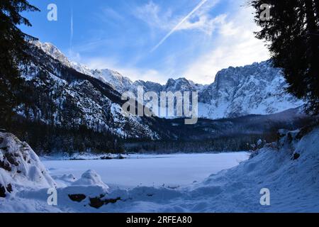 Surface gelée du lac lago di fusine superiore près de Tarvisio dans la région Friuli-Venezia Giulia en Italie avec la montagne Kotova Spica dans les alpes juliennes Banque D'Images