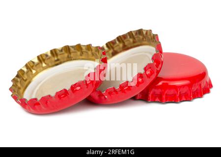 Un bouchon en métal de couleur rouge, utilisé pour les bouteilles en verre de soda. Isolé sur fond blanc. Banque D'Images