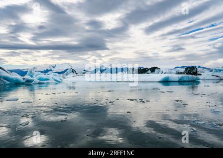 Icebergs bleus dans l'eau de l'océan. Dérive de glace du glacier à l'eau calme. Morceaux de glace pure du glacier Melting. Paysage hivernal glacé. Temps brumeux en Islande. Banque D'Images