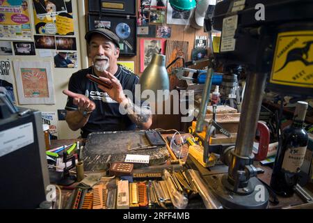 Etats-Unis, Mississippi, Clarksdale, bluesman Deak Harp personnalise les harmonicas dans sa boutique Banque D'Images