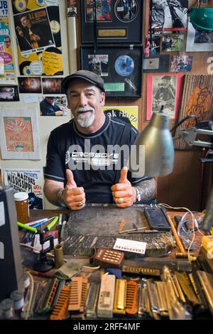 Etats-Unis, Mississippi, Clarksdale, bluesman Deak Harp personnalise les harmonicas dans sa boutique Banque D'Images