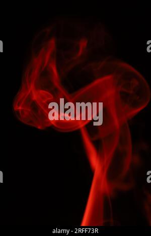 Fumée rouge sur fond sombre, motifs, abstrait brouillard rouge, photographie verticale Banque D'Images