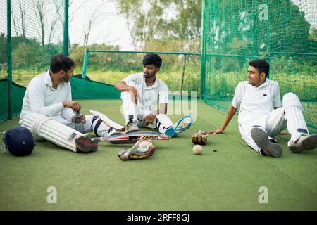 Les joueurs de cricket discutent en se parlant après avoir joué dans les filets. Banque D'Images