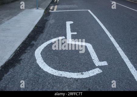 Une photo d'un panneau de place de stationnement pour personnes handicapées sur une surface de route. Banque D'Images