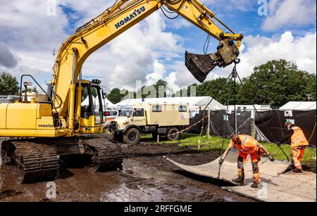 Wacken, Allemagne. 03 août 2023. Les techniciens placent des panneaux flexibles sur les chemins boueux pour permettre le passage. Le Wacken Open-Air (WOA) du 2 au 5 août est considéré comme le plus grand festival de heavy Metal au monde. Crédit : Axel Heimken/dpa/Alamy Live News Banque D'Images