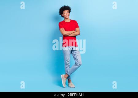 Portrait complet du corps de gentil étudiant multinational croisant les mains annonçant de nouveaux vêtements de collection isolé fond de couleur bleue Banque D'Images