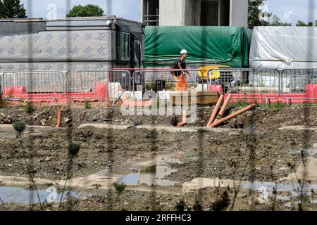 Lockleaze, Bristol, Royaume-Uni. 3 août 2023. Un développement de maisons modulaires a rencontré des problèmes structurels conduisant à la nécessité de démonter et reconstruire les maisons. La construction de maisons modulaires utilise des composants préfabriqués qui sont assemblés sur place pour donner une construction plus rapide. Malheureusement, des problèmes avec les fondations ont fait en sorte que les nouvelles maisons n'auraient pas satisfait au contrôle de qualité de la NHBC. Le développeur L&G travaille avec des acheteurs de maisons qui font face à des retards. Sur la photo sont la fondation gorgée d'eau d'une ancienne maison avec des modules de maison déconstruits derrière. Crédit : JMF News/Alamy Live News Banque D'Images