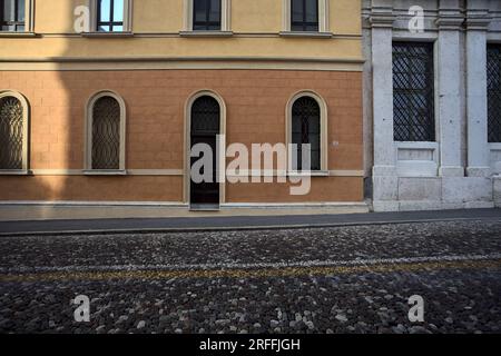 Portes en bois des bâtiments sur une rue pavée dans une ville italienne au coucher du soleil Banque D'Images