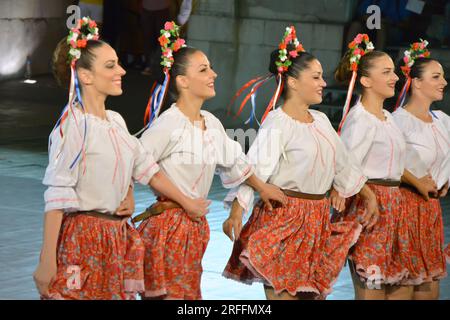 Un groupe de danseurs de la République de Serbie en costumes colorés exécutent une danse traditionnelle au XXI Festival International de folklore à anci Banque D'Images