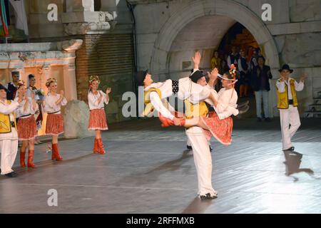 Un groupe de danseurs de la République de Serbie en costumes colorés exécutent une danse traditionnelle au XXI Festival International de folklore à anci Banque D'Images