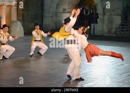 Un groupe de danseurs de la République de Serbie en costumes colorés exécutent une danse traditionnelle au XXI Festival International de folklore à anci Banque D'Images