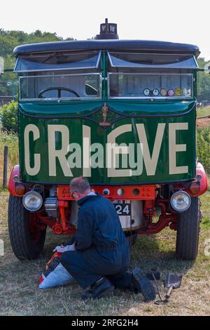 Homme travaillant sur le wagon à vapeur de 1931 camions à vapeur Sentinel au Roads to Rail Steam Rally à Norden, Dorset Royaume-Uni en juin Banque D'Images