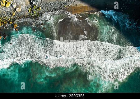 Prise aérienne plage volcanique pierreuse, point de vue drone brisant les vagues de l'océan Atlantique, surf lors d'une journée ensoleillée d'été. Sao Miguel, île de Ponta Delgada. AZ Banque D'Images